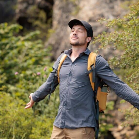Young man enjoying nature, breathing deeply the fresh air.