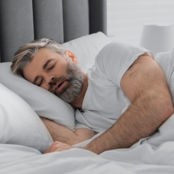 Man sleeping with mouth open, snoring due to nasal obstruction.